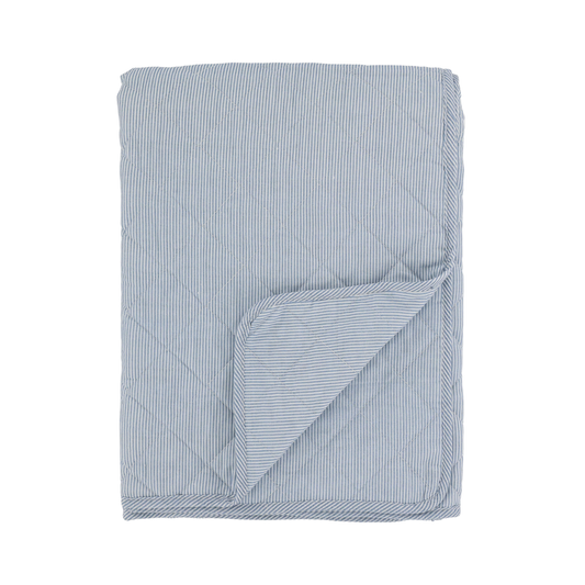 Blue and white striped quilt on a white background
