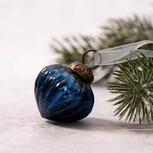 A small blue crackle glass lantern with a bronze cap and organza hanger, displayed against a neutral background with a hint of greenery.