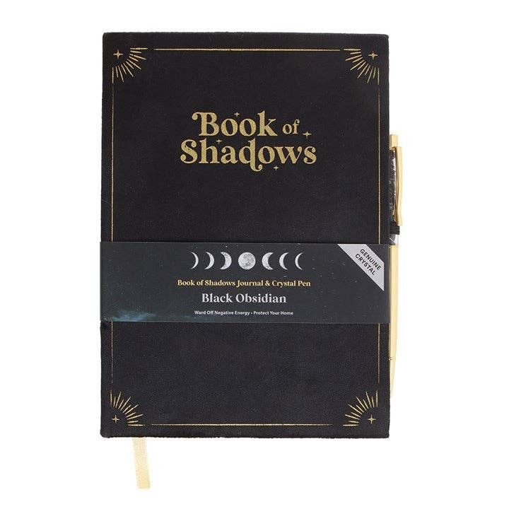 Black notebook titled 'Book of Shadows' with gold text on a white background