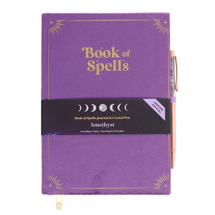 Purple journal titled 'Book of Spells' with a pen on a white background