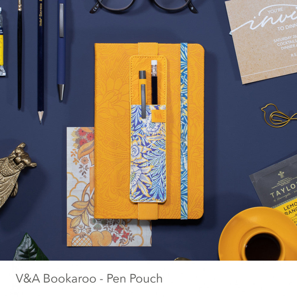 Yellow pen pouch with floral design on a blue background with stationery items.