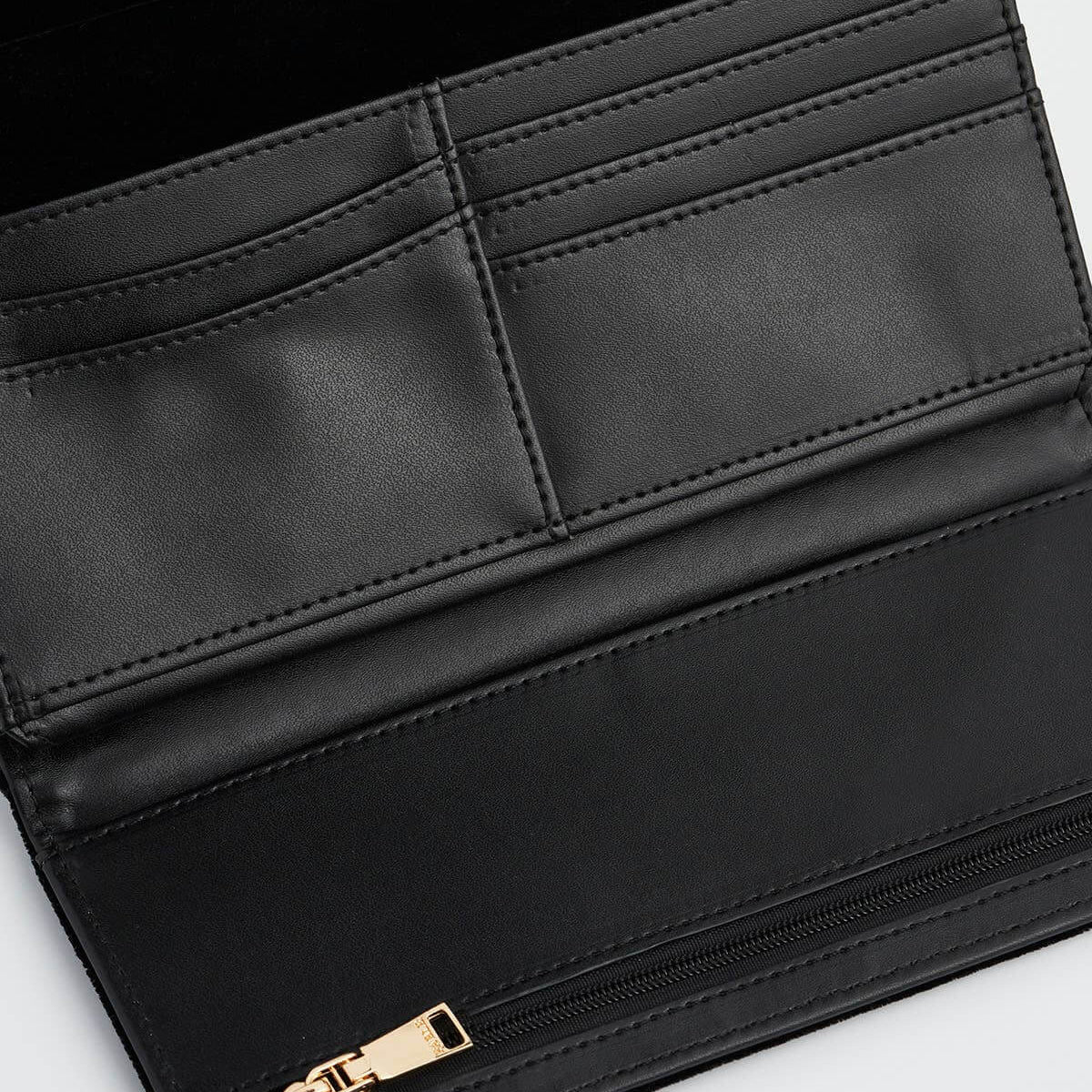 Close-up of a black leather wallet with a gold zipper on a light gray background