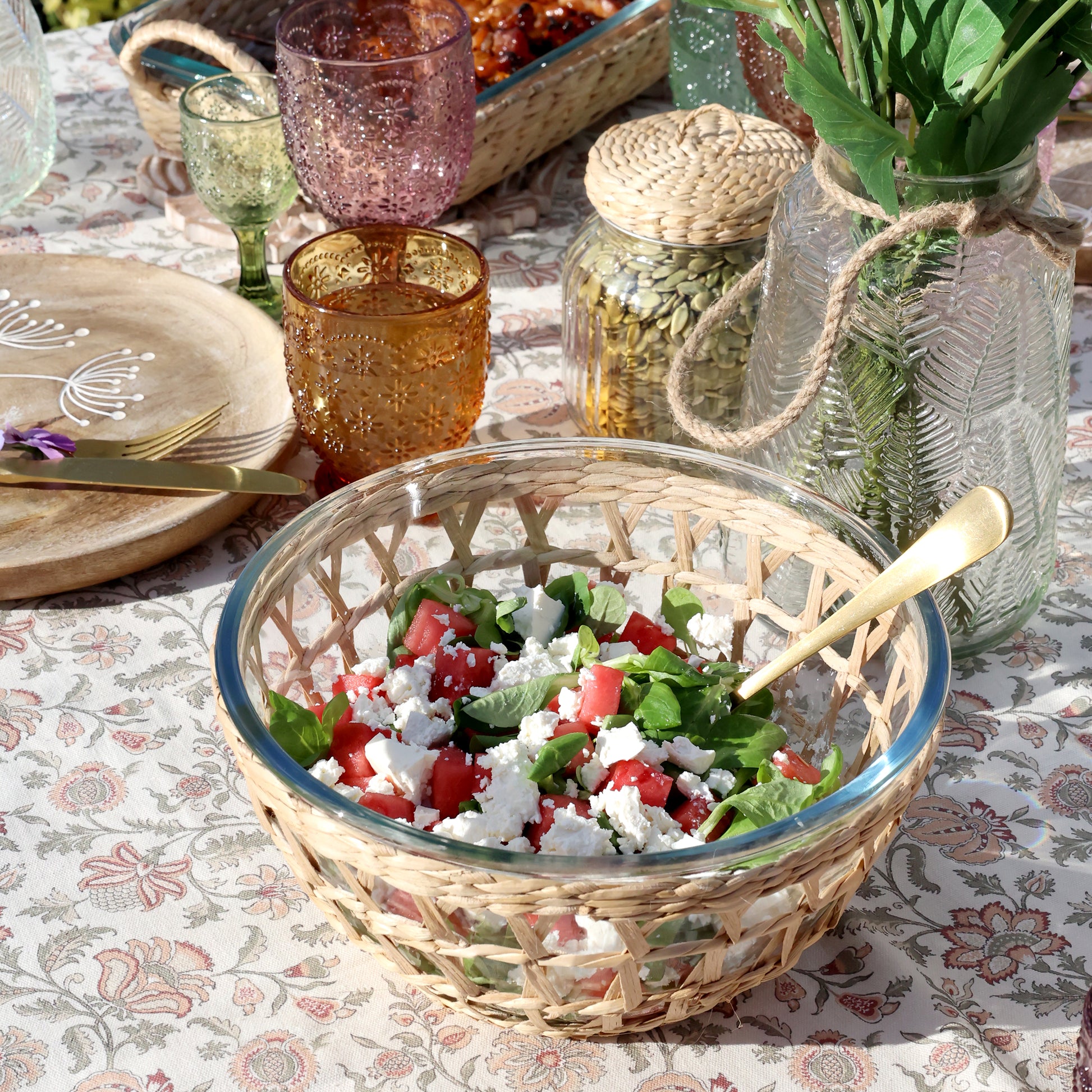 Wicker bowl with salad on a patterned tablecloth
