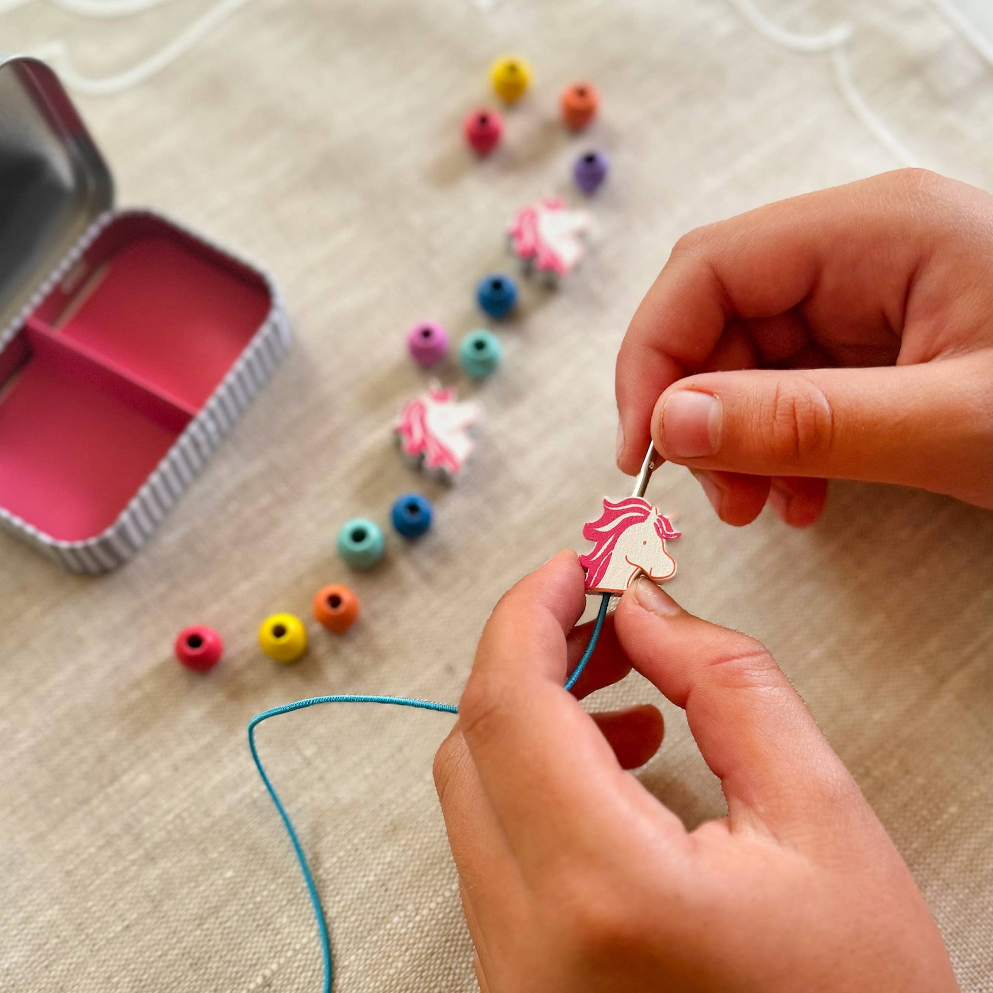 Someone making a beaded bracelet