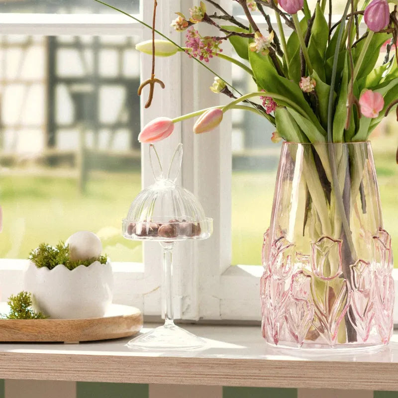 Decorative table setting with a pink floral vase and spring flowers.
