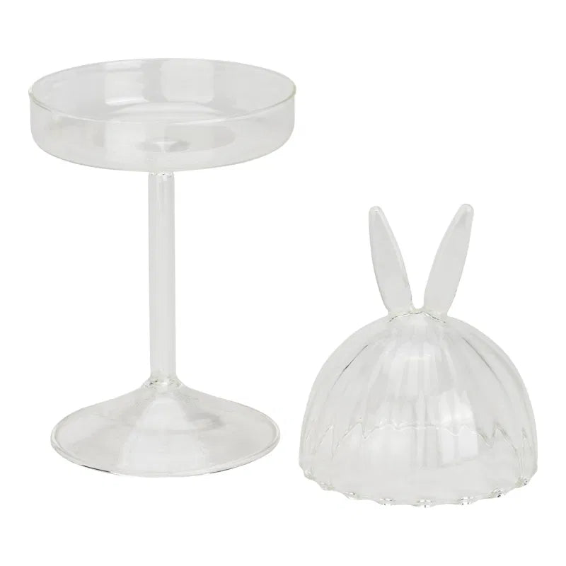 Transparent glass lid with rabbit ears and a round transparent dish on a white background