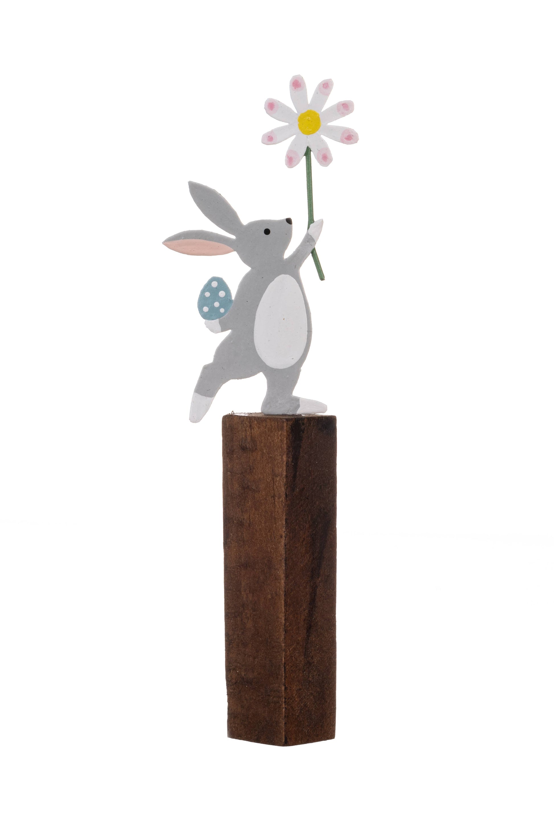Decorative figure of a rabbit holding a flower on a wooden block against a white background