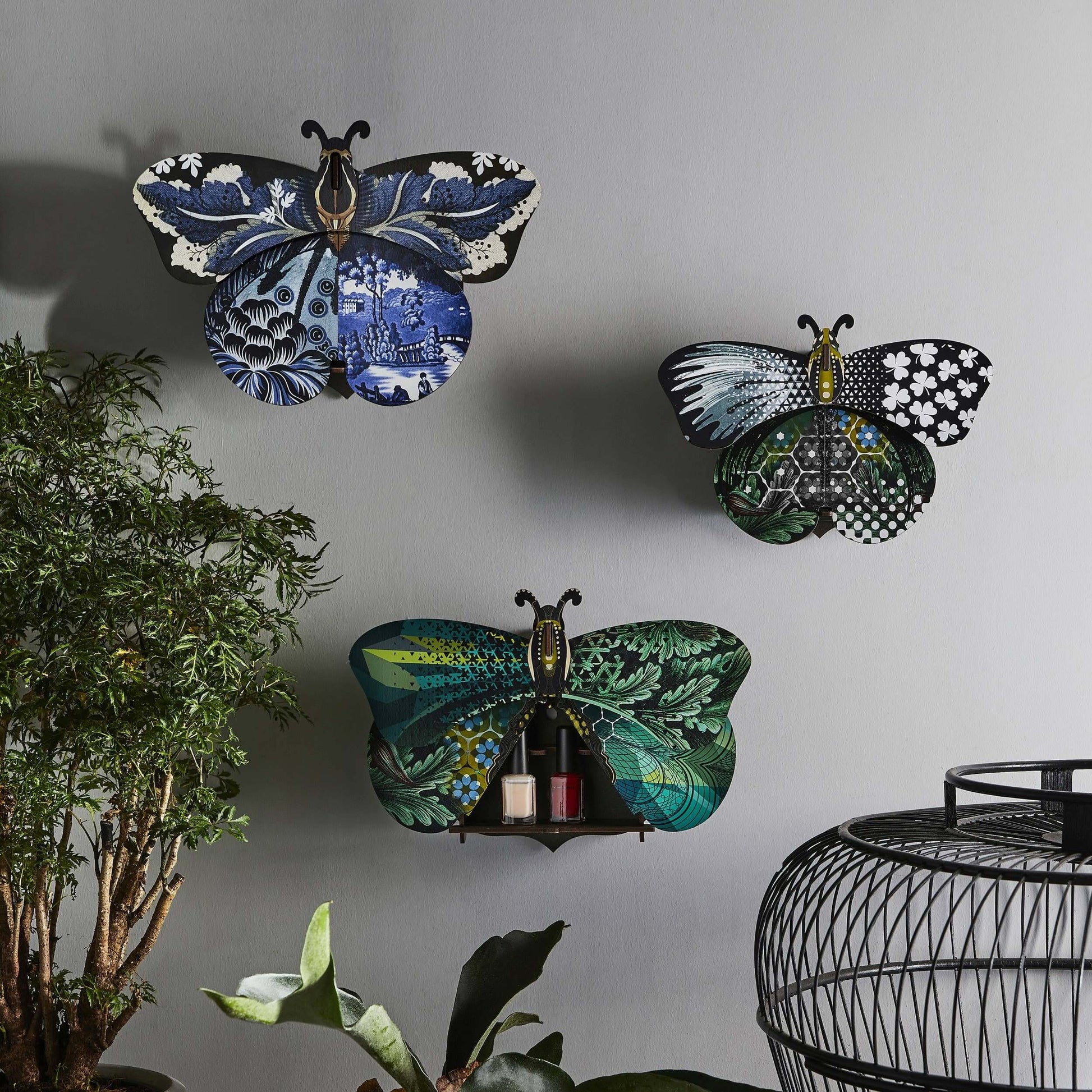 A decorative butterfly wall decor with hidden storage compartment, featuring a mix of floral and geometric patterns in a blue color palette.