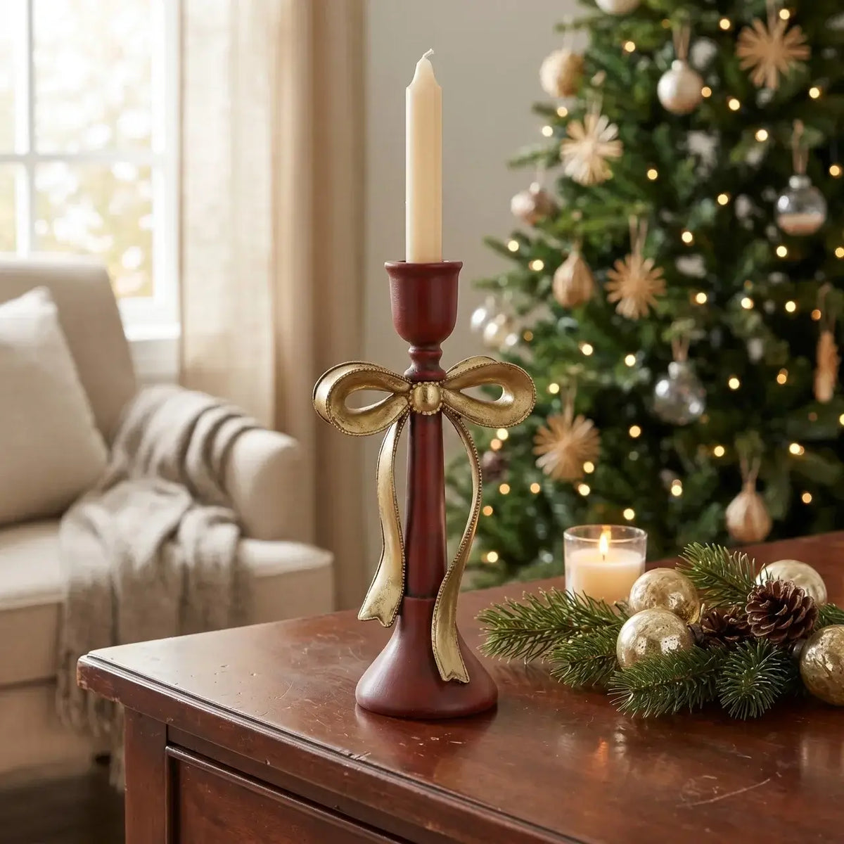 Decorative candle holder with a gold bow on a wooden table in a festive living room.