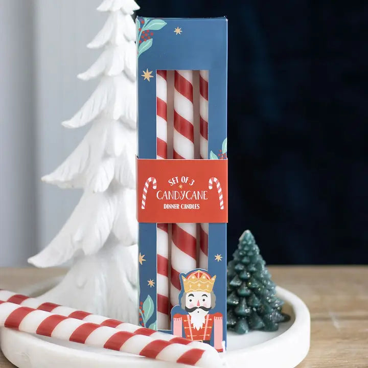 Set of candy cane dinner candles in a decorative box with Christmas-themed design.