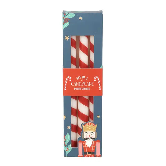 Box of red and white candy cane striped festive candles on white background