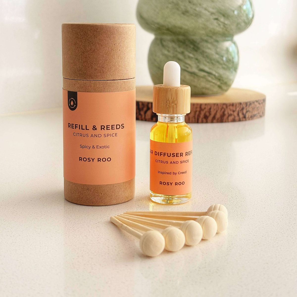 Refill and reeds diffuser bottle with packaging and wooden sticks on a light surface.