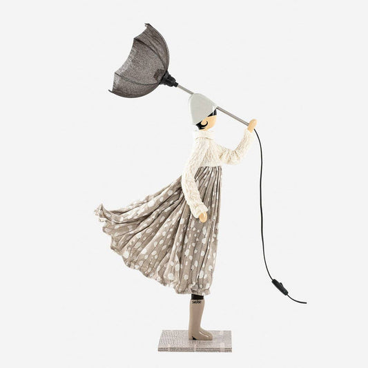 Decorative lamp of a figure of a lady holding an umbrella on a white background