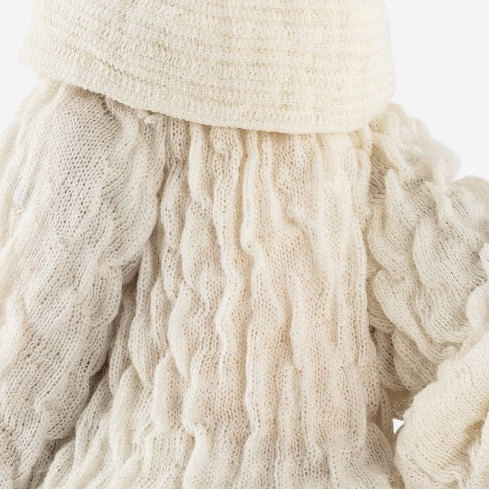 Close-up of a cream-colored jumper with a textured pattern of the Carmela lamp on a white background
