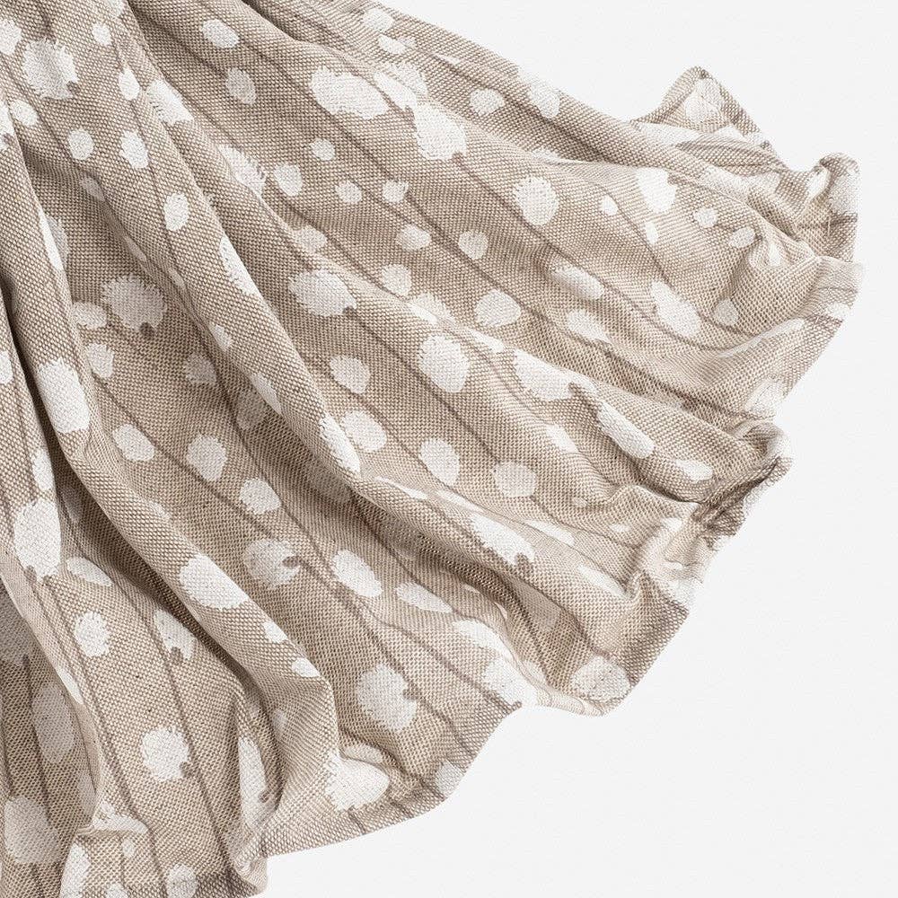 Textured fabric with white floral pattern on a light background. close up of Carmela lamp's skirt