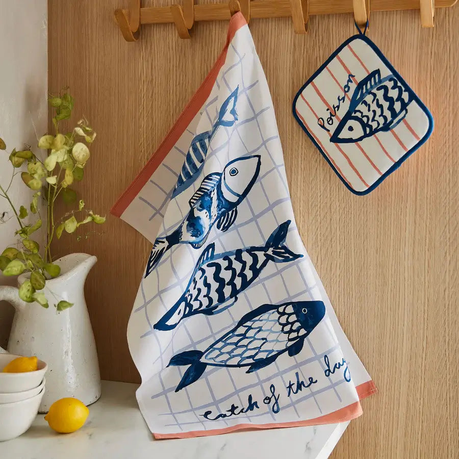 Kitchen towel with fish design hanging on a wooden rack