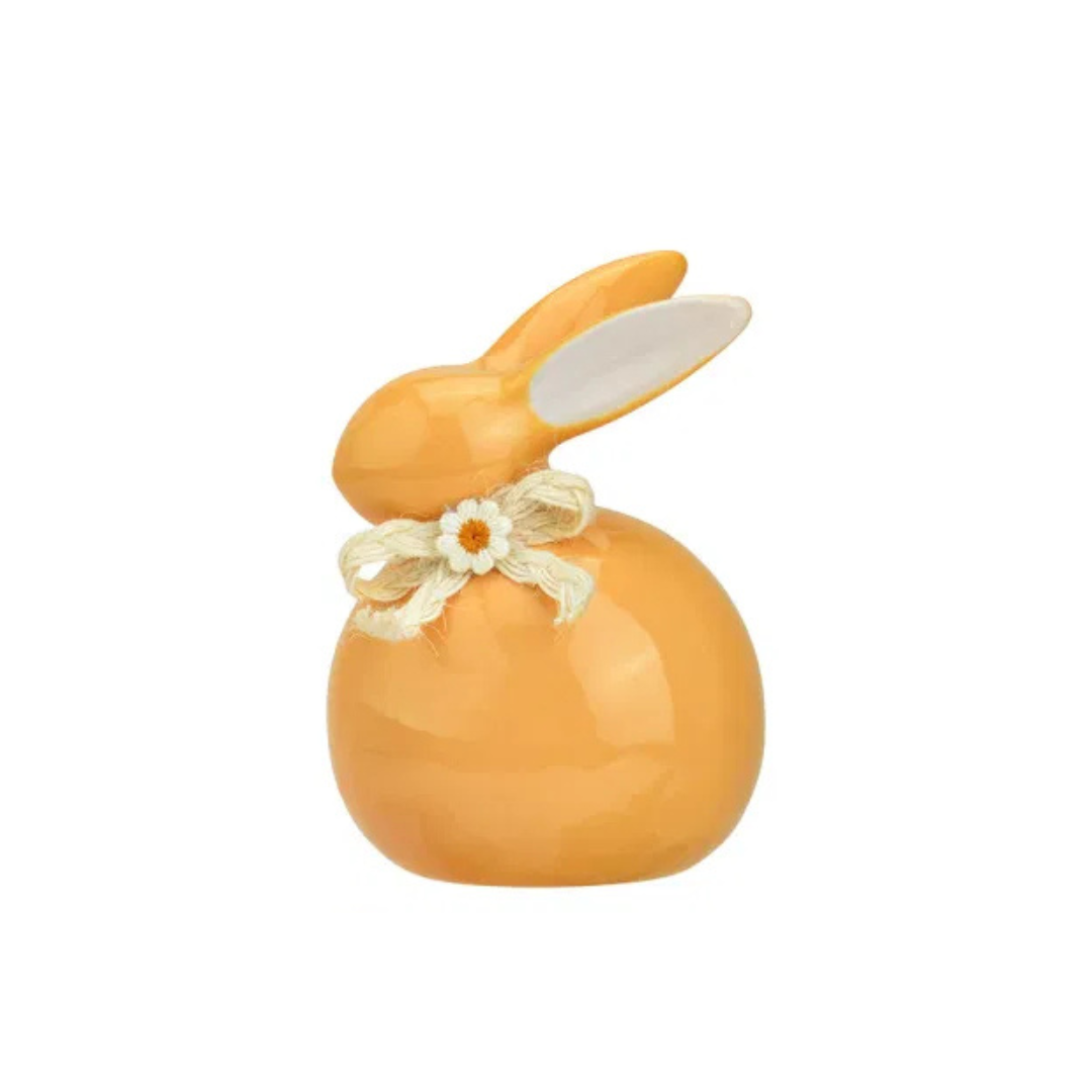 Decorative orange rabbit figure with a bow on a white background