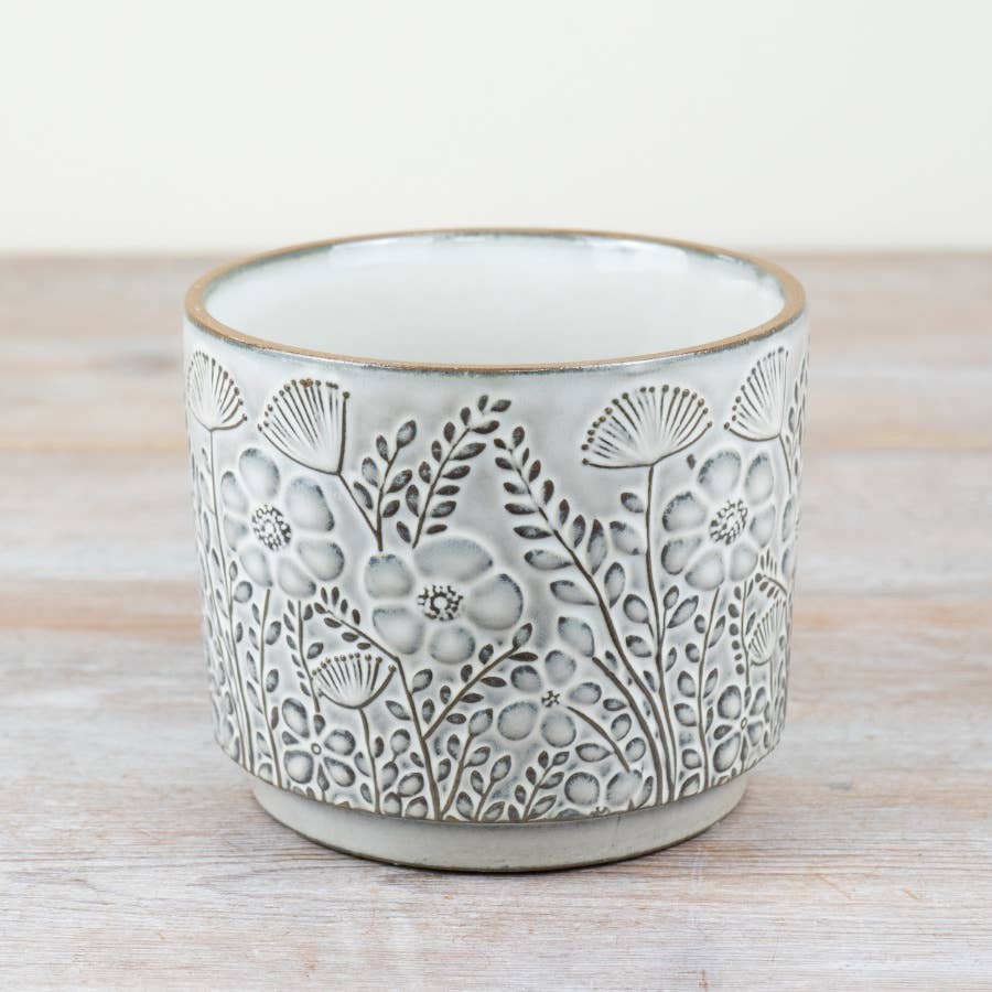 Ceramic planter with floral patterns on a wooden surface