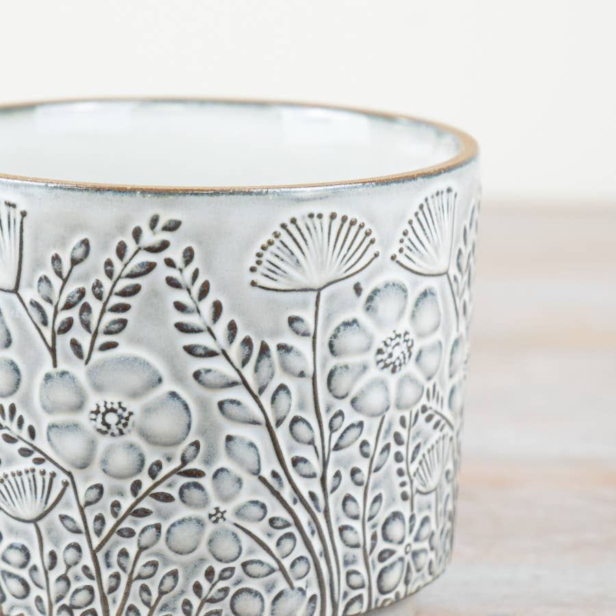 Ceramic vase with floral patterns on a wooden surface