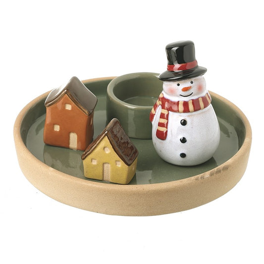 Ceramic snowman with a scarf and hats, small houses, and a round dish on a white background