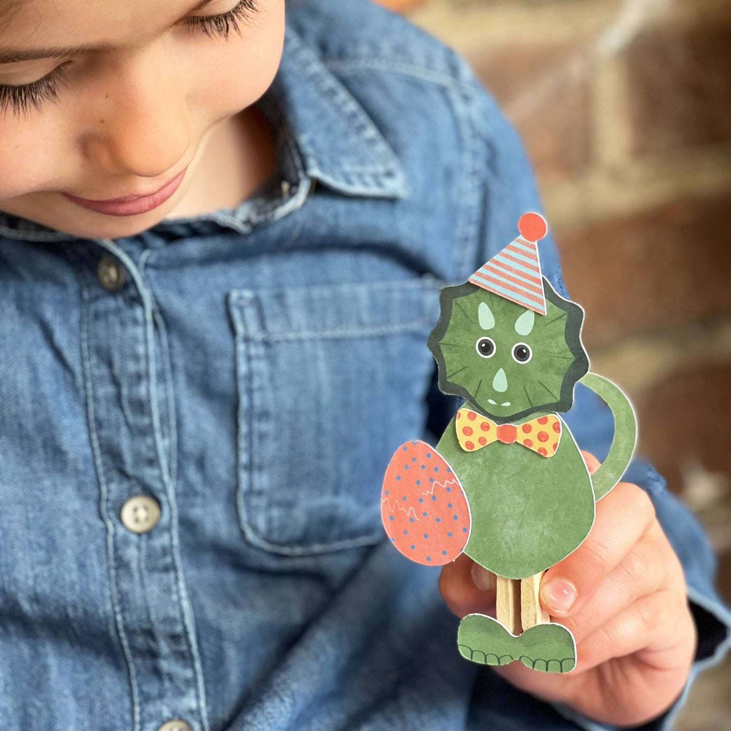 Child holding a Dinosaur Peg Doll-Make Your Own