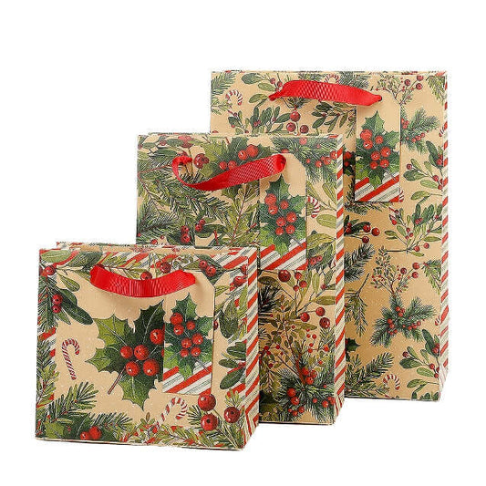 Three Christmas-themed gift bags with red ribbon handles, featuring a holly and pine pattern on a beige background, arranged against a plain white background.