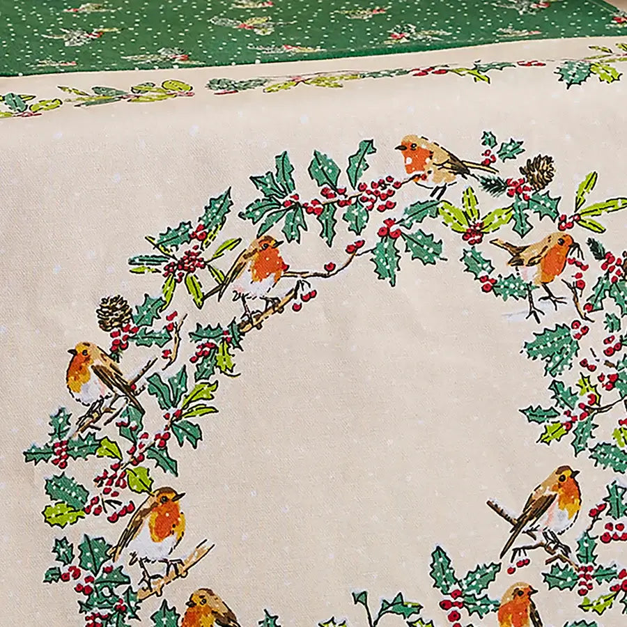 Fabric with a Christmas design featuring holly leaves, berries, and birds on a beige background.