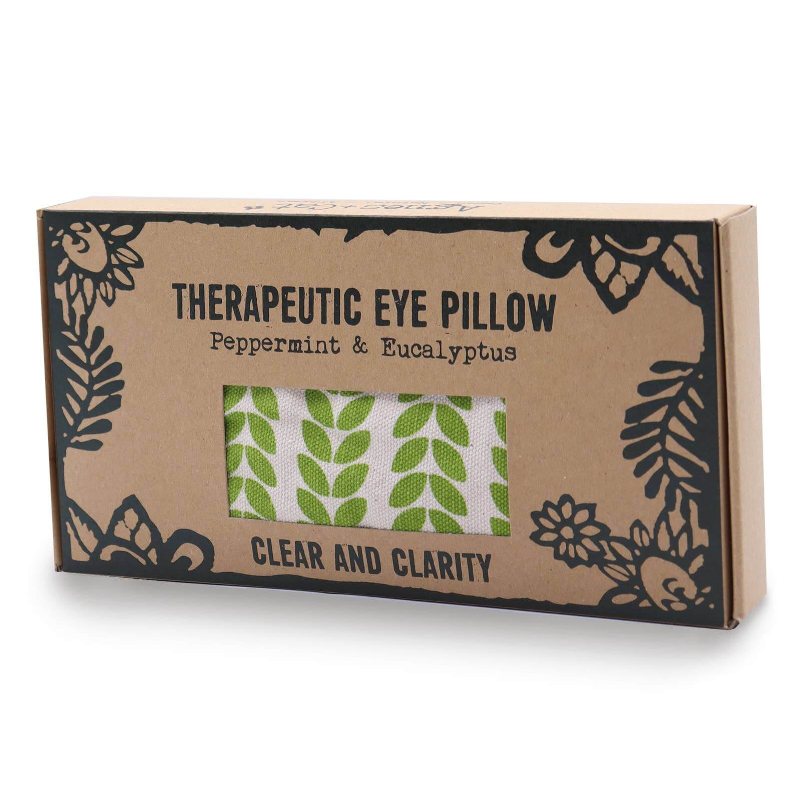 A cardboard packaging of a therapeutic eye pillow with a window displaying the product. The design includes black floral patterns and text, with the title 'THERAPEUTIC EYE PILLOW' and 'Peppermint & Eucalyptus'.