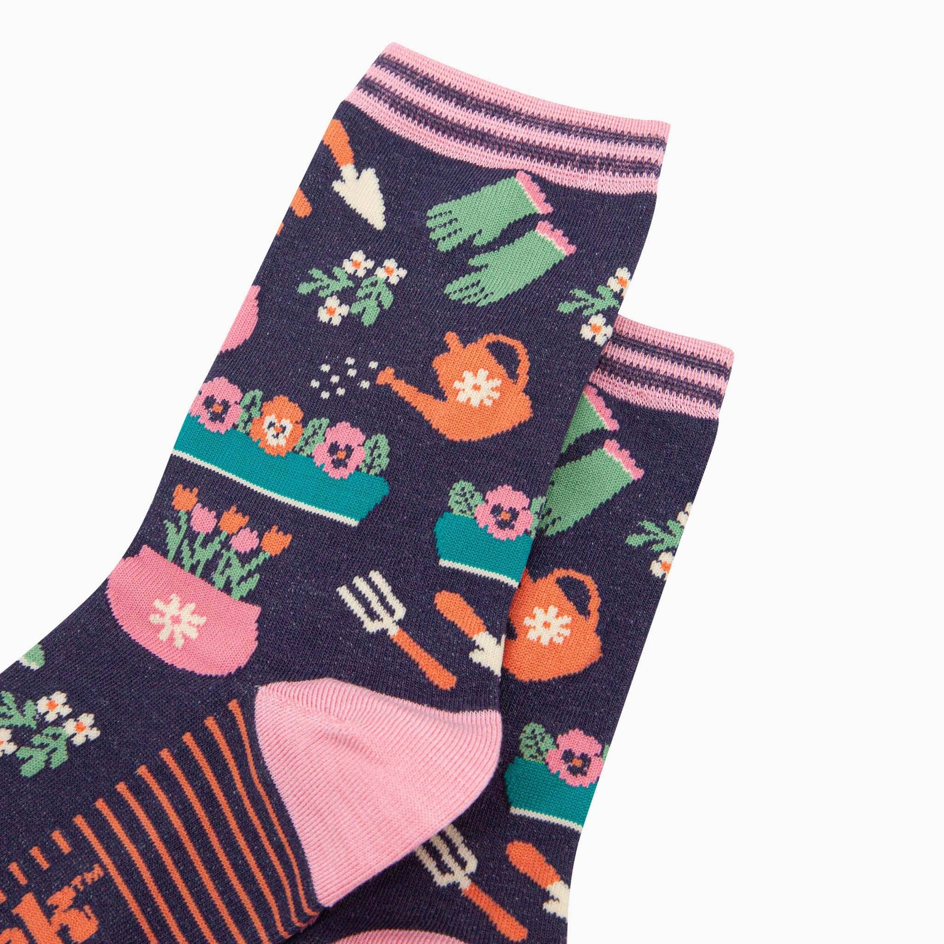 Gardening-themed socks with tools and plants on a dark background