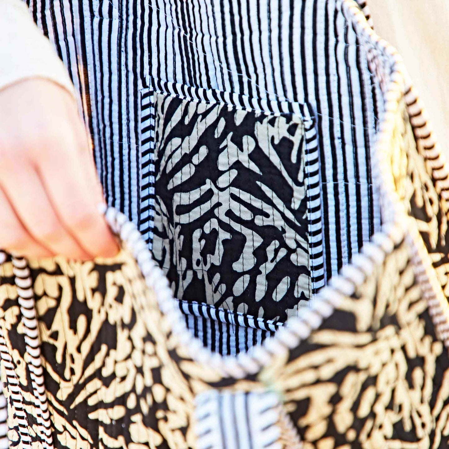 Close-up of a fabric with black and white patterned pocket on a textured surface.