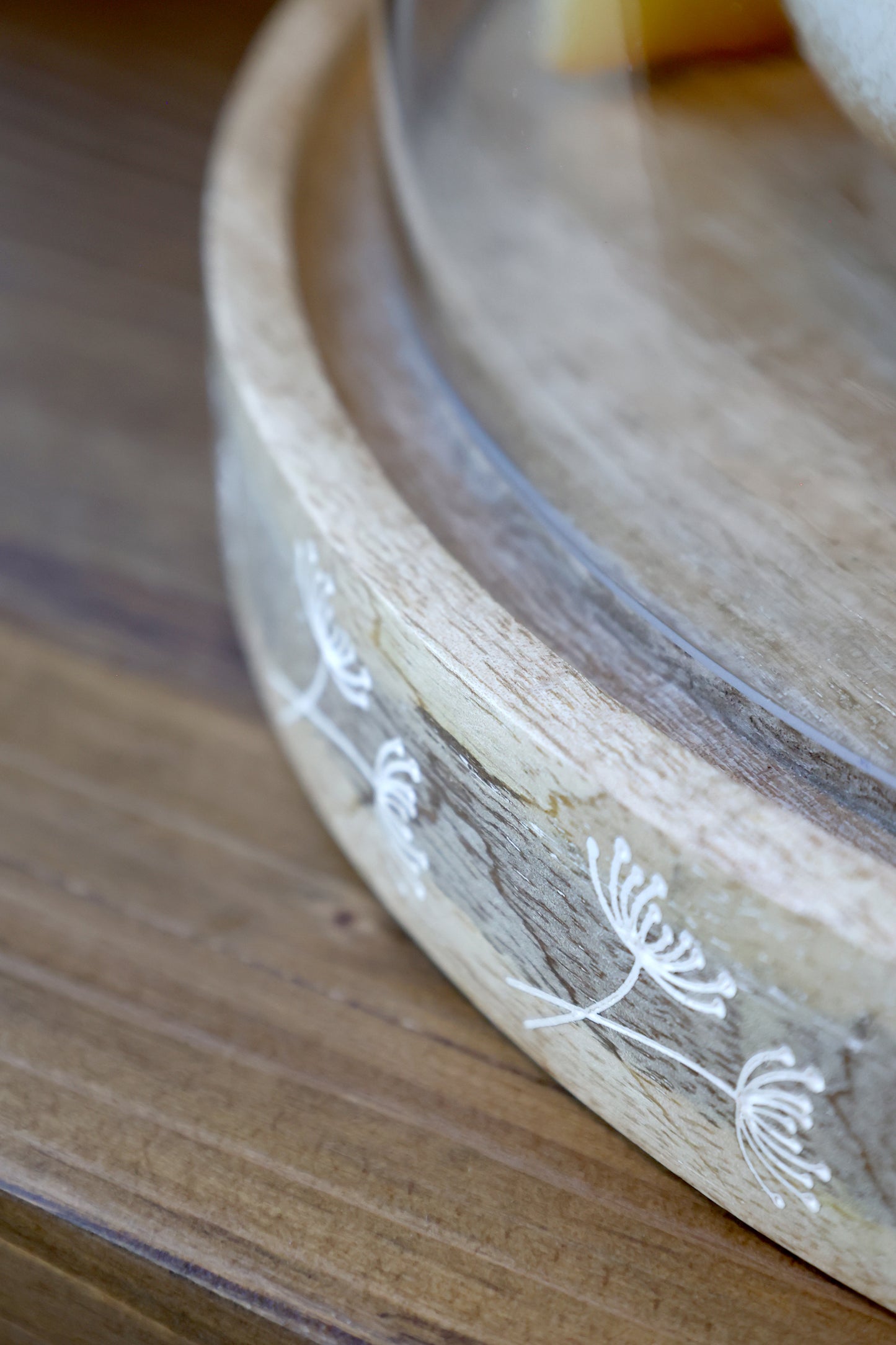 Wooden tray with floral embossing on a wooden surface
