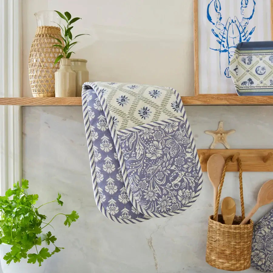 Floral-patterned towel hanging on a wooden shelf with decorative items.
