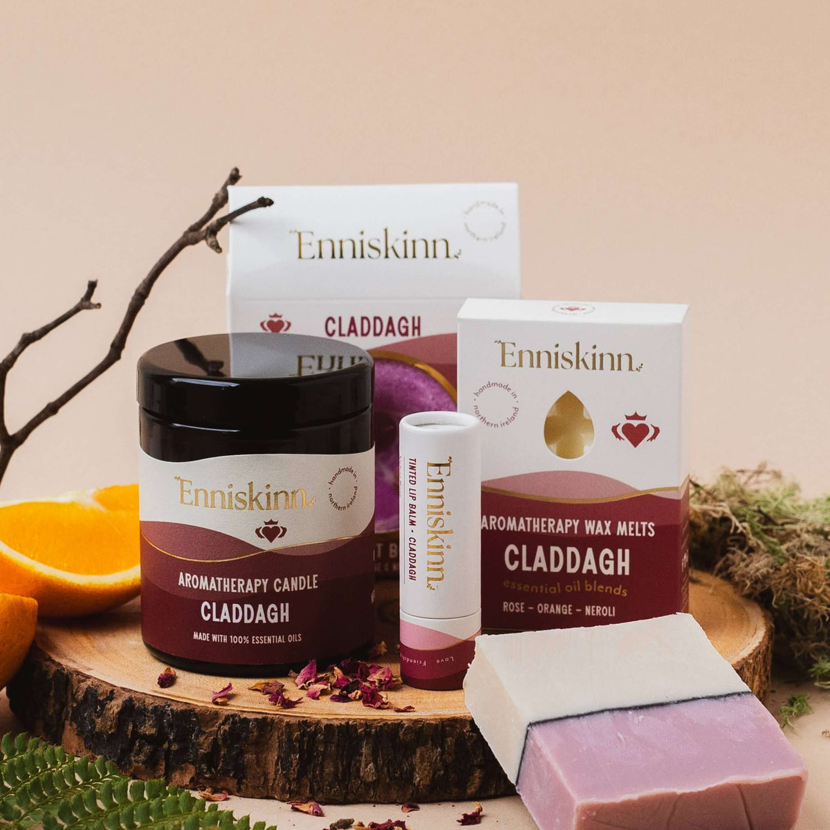 Collection of Enniskinn skincare and wellness products on a wooden surface with natural elements.