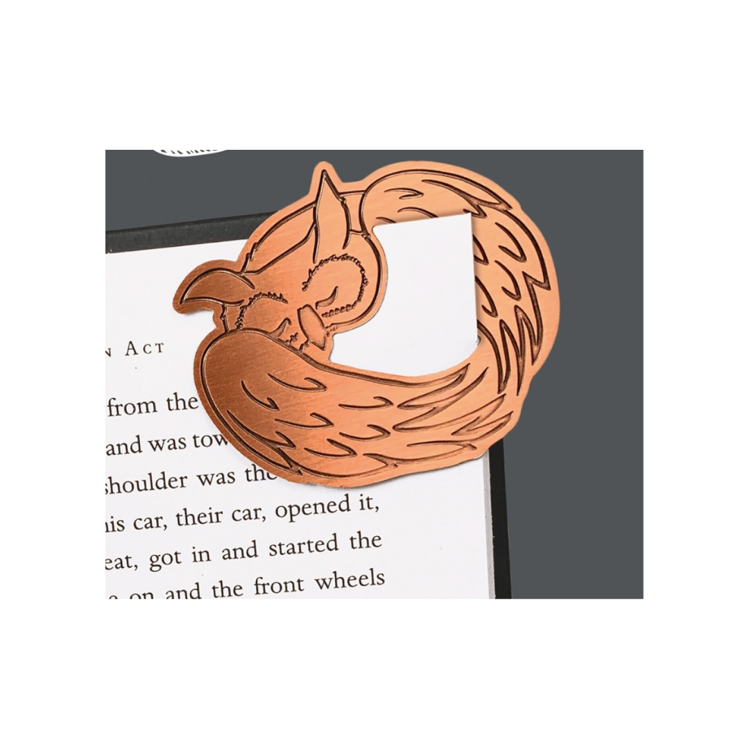 Copper fox-shaped bookmark on a book page