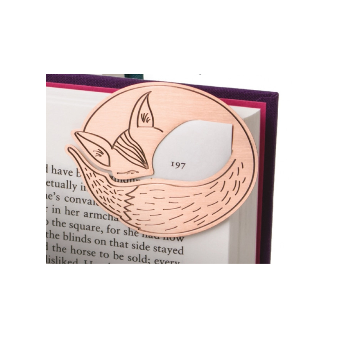 Rose gold fox-shaped bookmark on a book with visible text