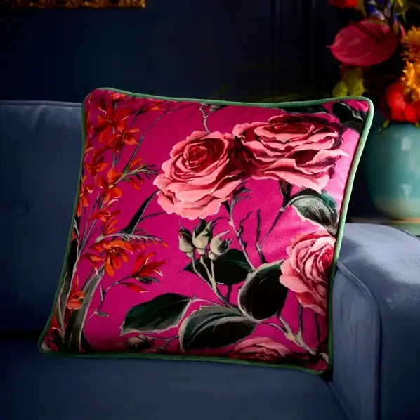 Floral pillow with pink roses on a blue sofa