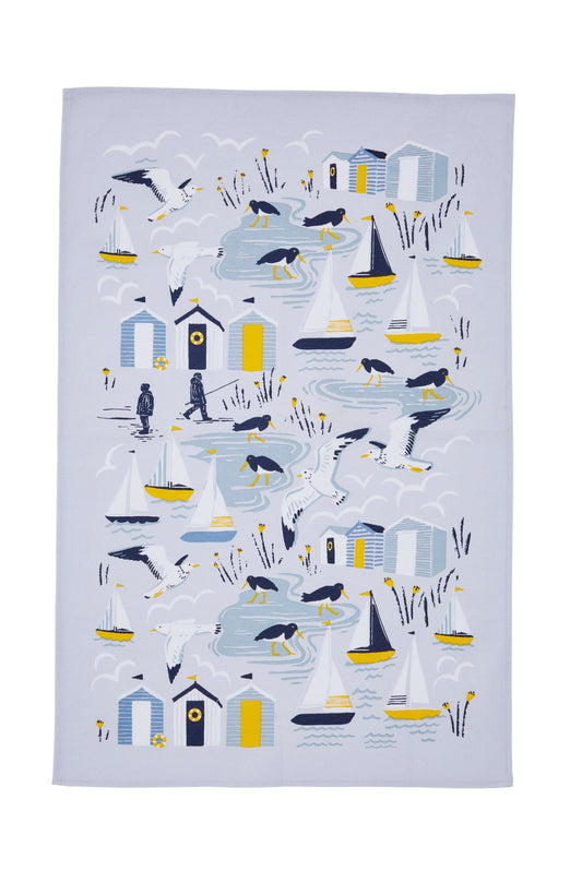 Tea towel with coastal design featuring sailboats, lighthouses, and other sea-themed elements on a white background.