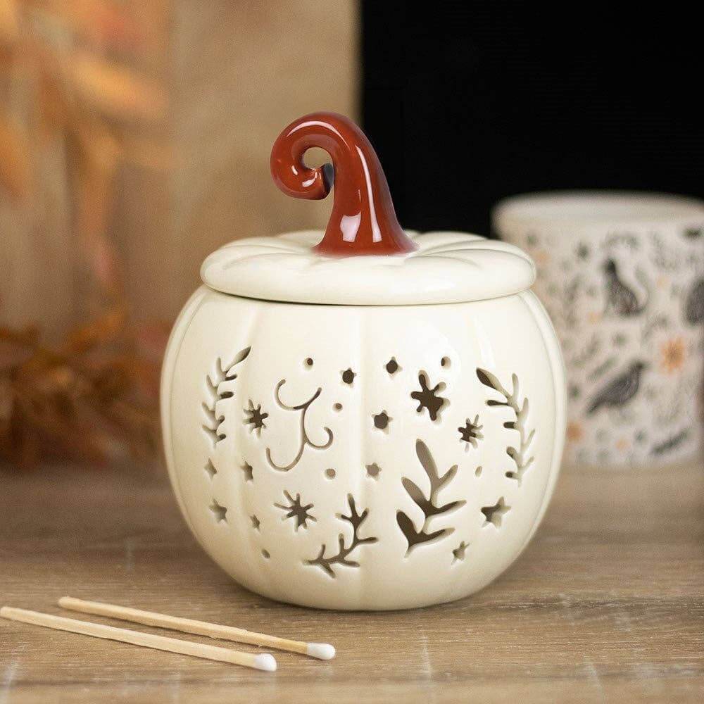 Decorative ceramic lantern with a red handle on a wooden surface, surrounded by matches.