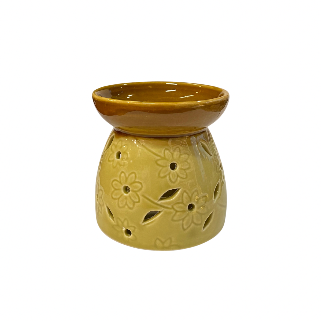 Yellow ceramic oil burner with floral designs on a white background