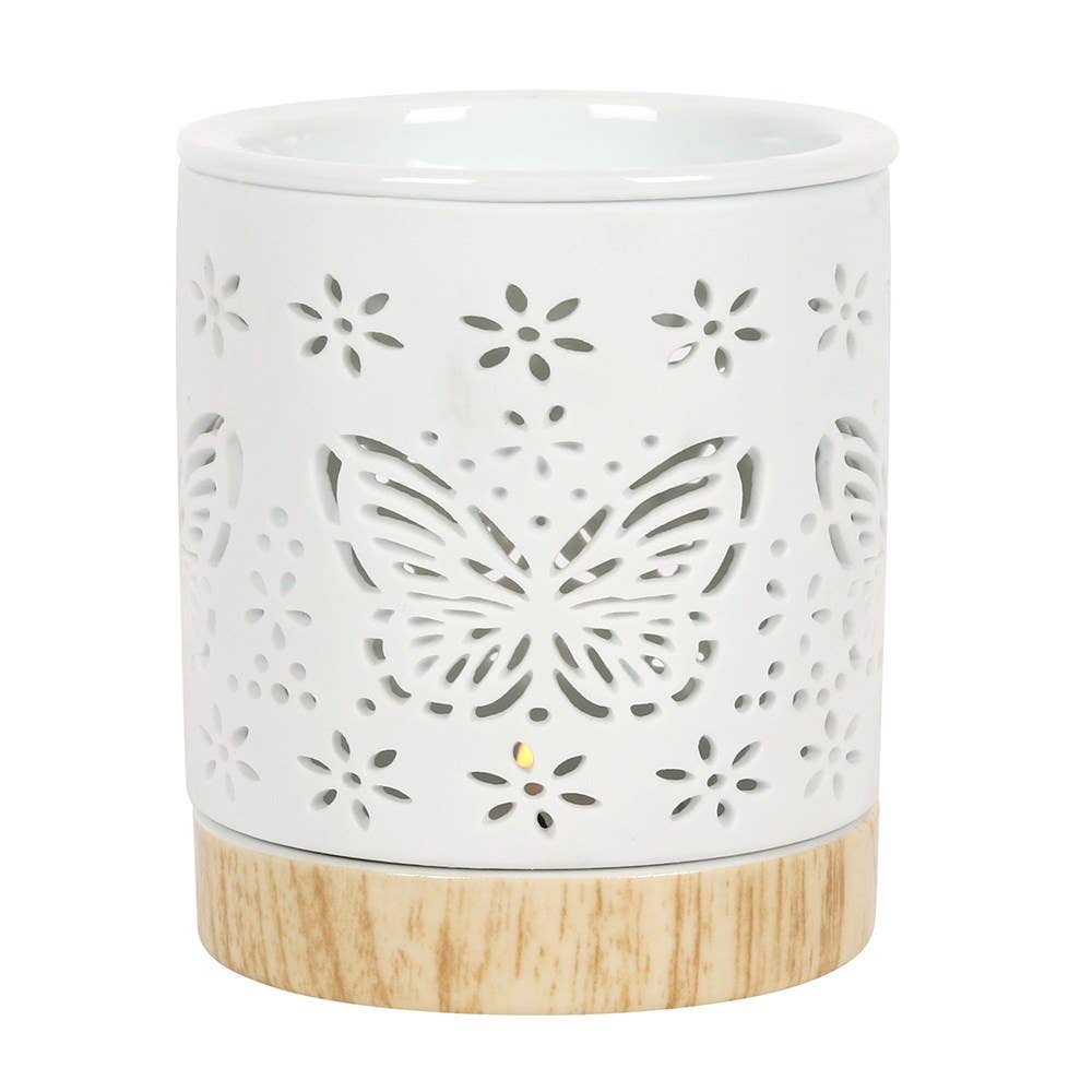 White ceramic wax warmer with butterfly design and wooden base on a white background