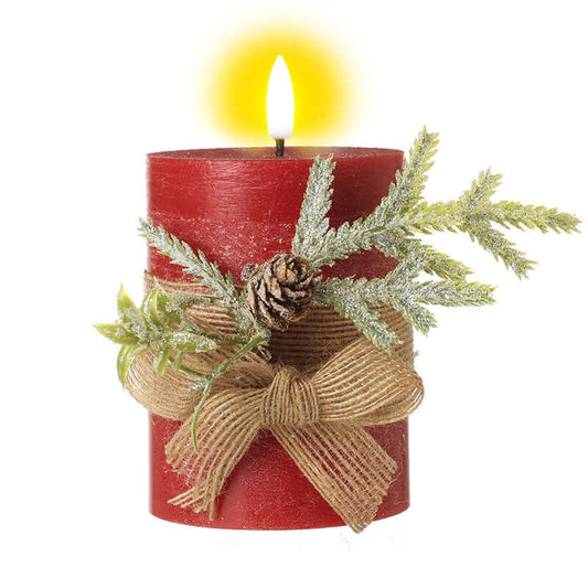 Decorative red candle with a bow, pine cone, and greenery on a white background