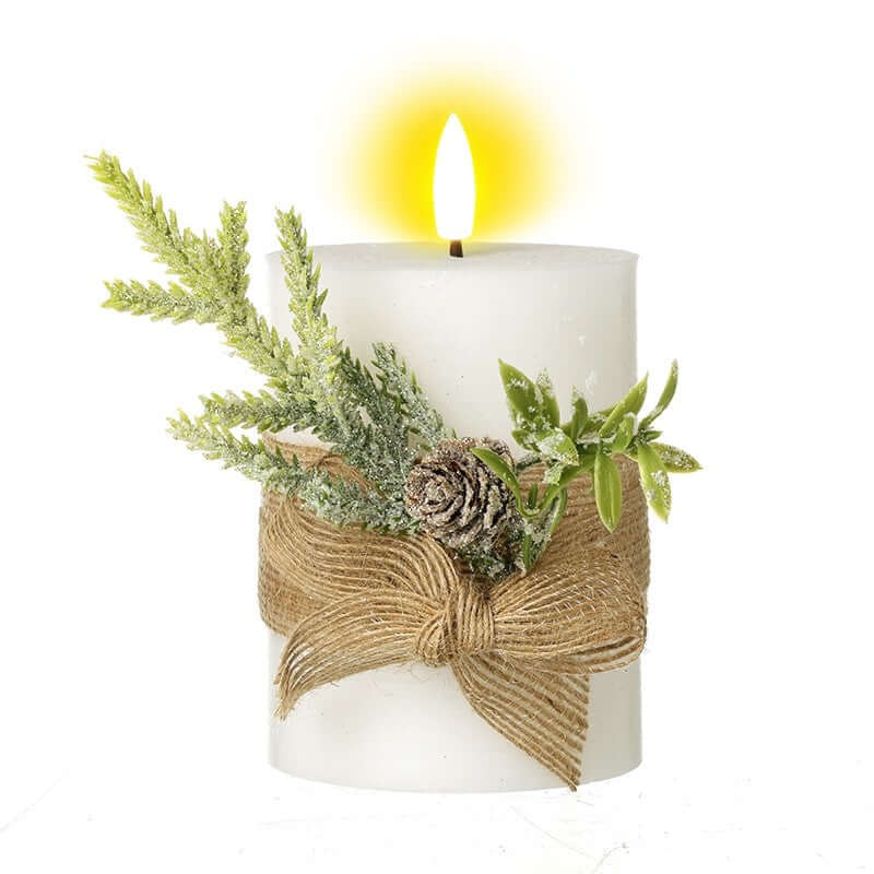 White candle with decorative jute wrap and greenery on a white background