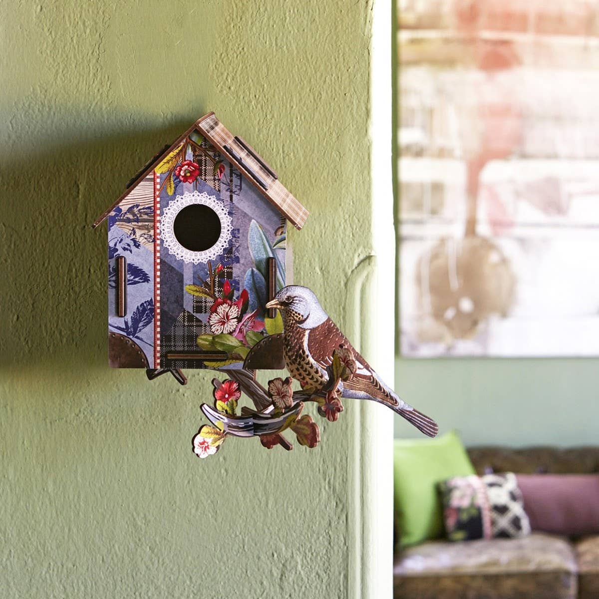 Decorative birdhouse with a bird on a green wall
