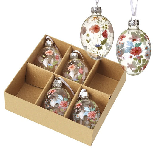 Set of floral glass ornaments in a cardboard box on a white background