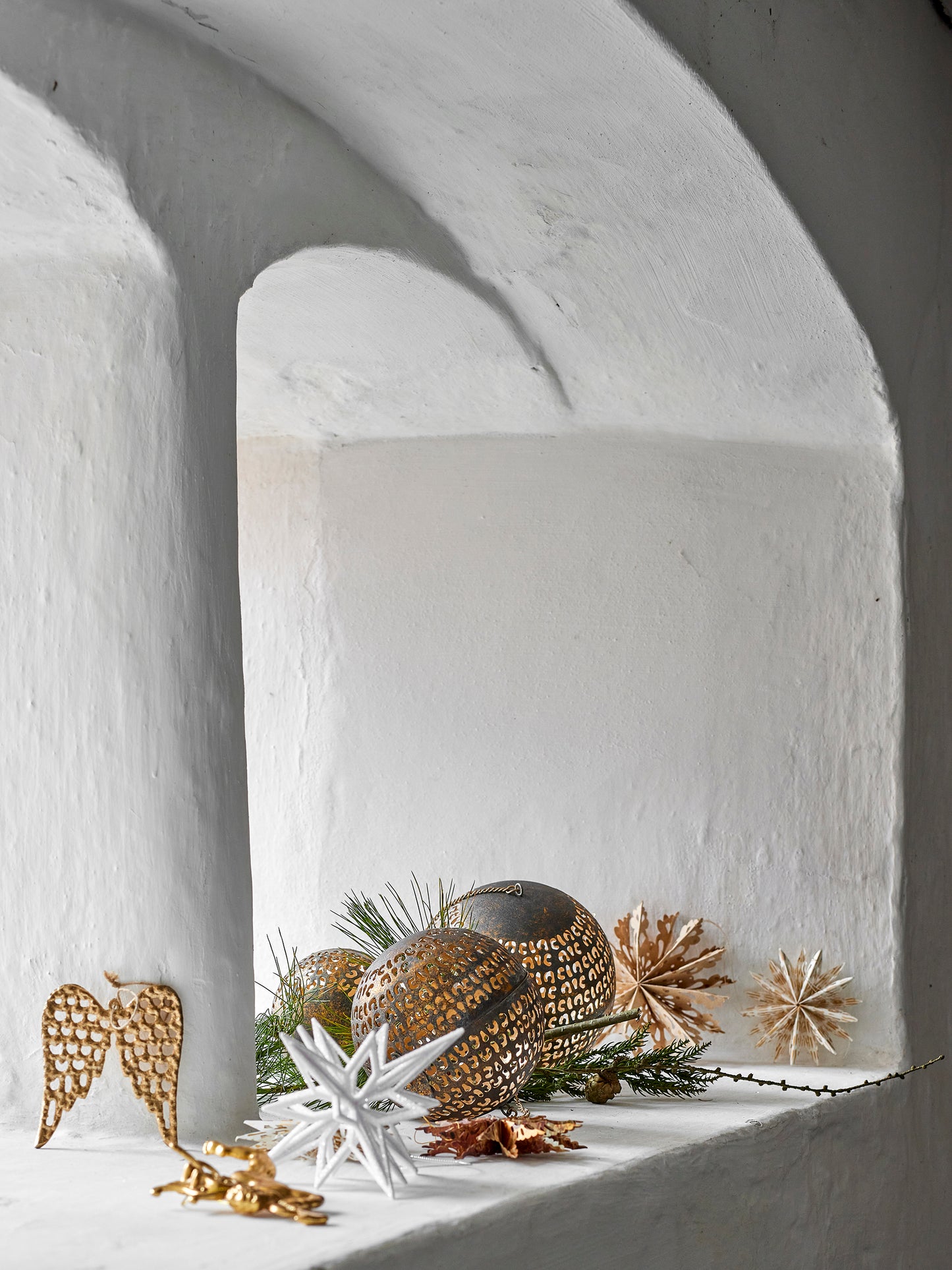 Decorative arrangement with gold and silver ornaments on a white surface.