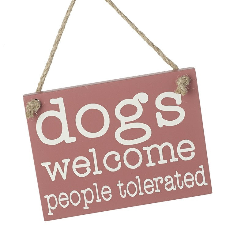Pink sign on string 'Dogs welcome people tolerated' on white background