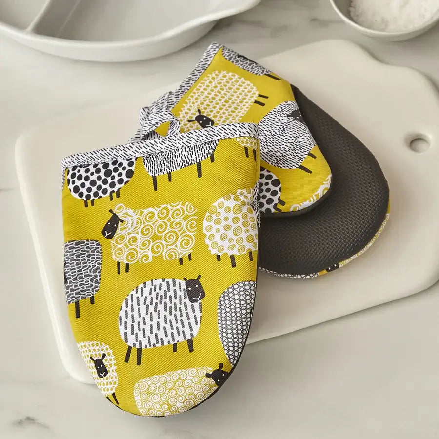 Yellow pot holder with sheep pattern on a white surface