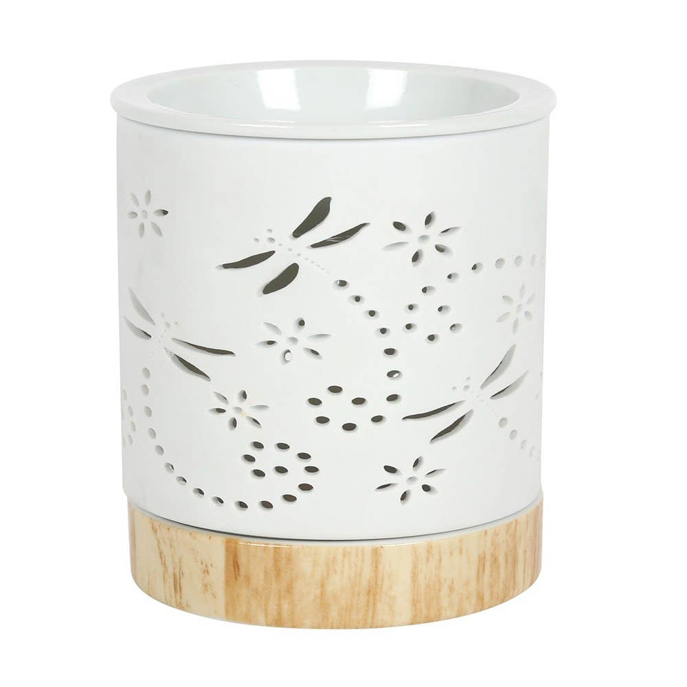 White ceramic wax warmer with floral cutout design on a wooden base against a white background