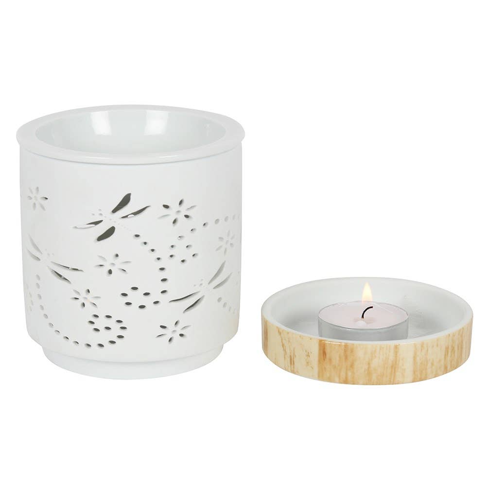 White ceramic candle holder with floral patterns and a wooden base with a lit candle on a white background