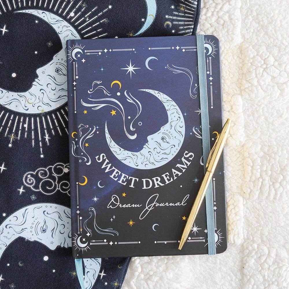 Dream journal with celestial design and pen on textured surface